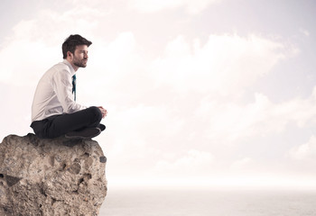 Business man sitting on stone edge