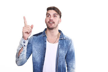 Attractive young man pointing up surprised