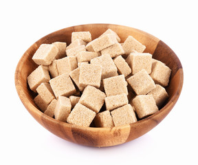 Natural sugar cubes in wood bowl on white background