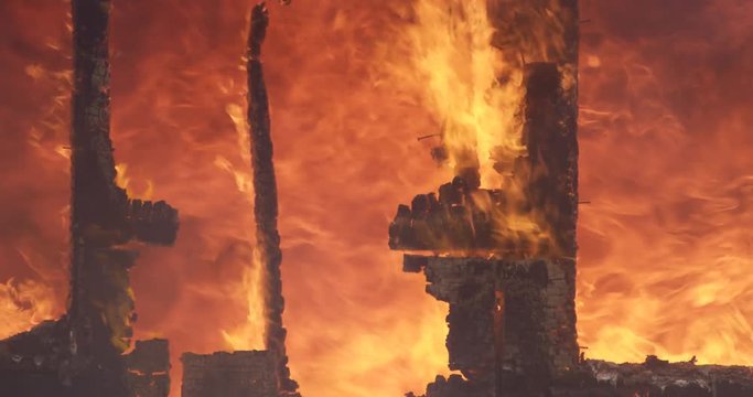 Raging fire seen through remains of a wall