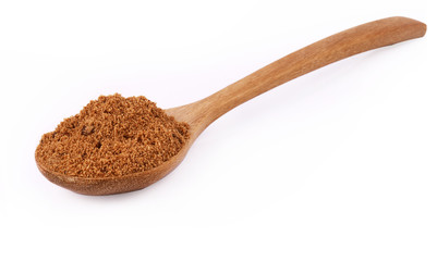 Natural browh sugar in spoon on white background