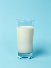Fresh glass of milk on blue background