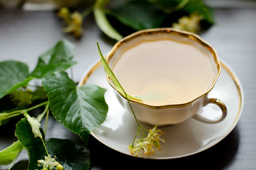 porcelain Cup of Linden tea on a background of dark wood