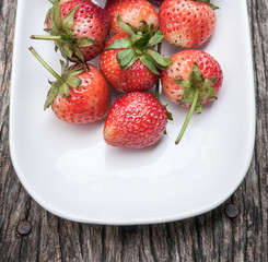 Small white filled with succulent juicy fresh ripe red strawberr