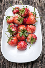 Small white filled with succulent juicy fresh ripe red strawberr