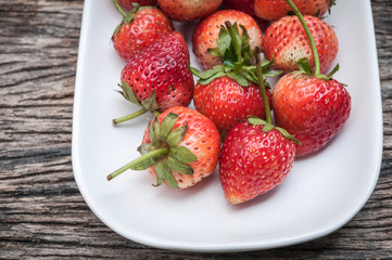 Small white filled with succulent juicy fresh ripe red strawberr