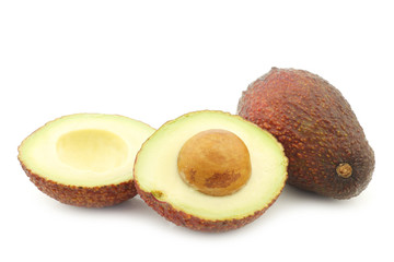 Eat ripe avocado and a cut one on a white background
