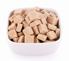 Natural sugar cubes in bowl on white background