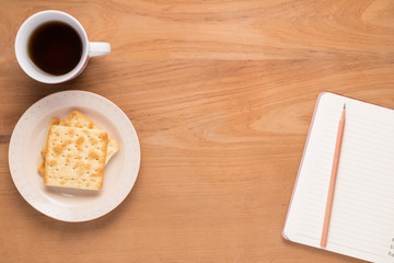 Mobile phone, notebook, pencil, coffee, tea, food cracker