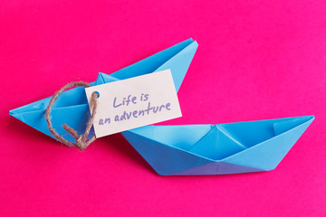 Paper Boat with a sign Life is adventure- travel concept