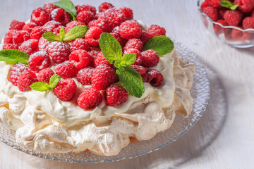 Meringue Pavlova  with whipped cream and fresh raspberries.