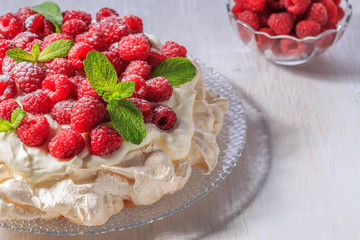 Meringue Pavlova  with whipped cream and fresh raspberries.