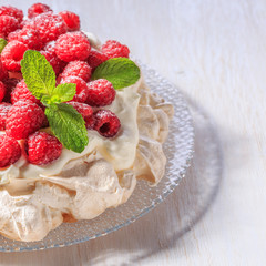 Meringue Pavlova  with whipped cream and fresh raspberries.