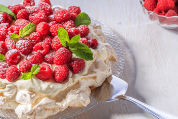 Meringue Pavlova  with whipped cream and fresh raspberries.