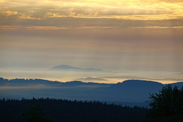 Fototapeta premium Wooded hills in the morning sun and fog
