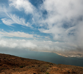 cloudy sky and view on the sea and neighboring isle coastline from Lanzarote, Canary Isles, Spain