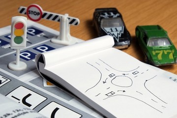 Notepad, book of traffic rules and pen on a desk table. Studying and preparing for driving test exam