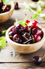 Black sweet cherry and mint on the wooden table