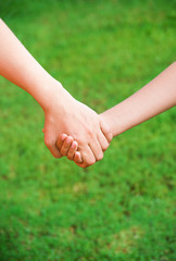 Mother holding a hand of his son in summer day outdoors