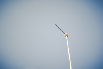 Old TV antenna in blue sky. (Vintage filtered)