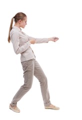 back view of standing girl pulling a rope from the top or cling