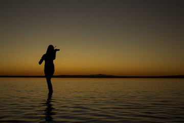 Turkey, women silhouette violin Salt lake at sunset