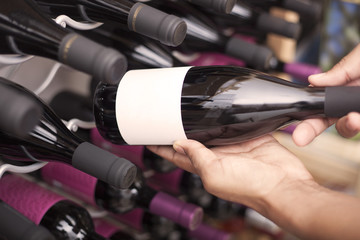 Wine taster showing wine bottles with copyspace