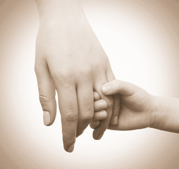 Child and mother hands together on light background