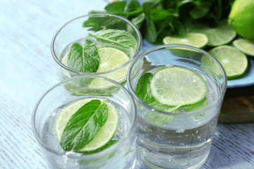 Infused lime water with mint on wooden background