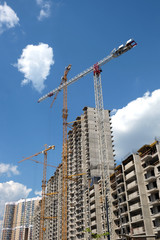 Fototapeta na wymiar New high-rise modern apartment buildings construction in process ob bright sunny day side view vertical