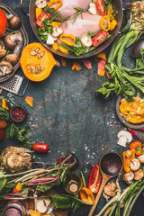 Chicken breast with Pumpkin , flavoring and organic garden vegetables ingredients, cooking preparation on dark rustic background, top view, frame.