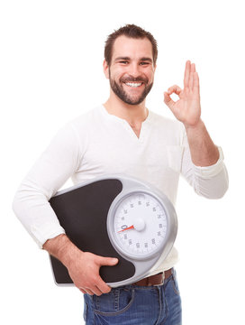 Handsome man with scale weight doing ok gesture