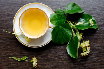 porcelain Cup of Linden tea on a background of dark wood