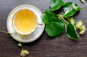 porcelain Cup of Linden tea on a background of dark wood
