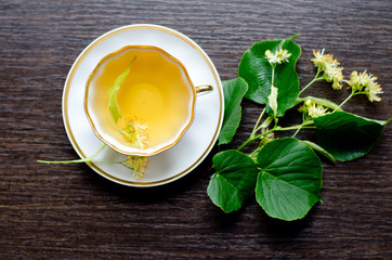 porcelain Cup of Linden tea on a background of dark wood