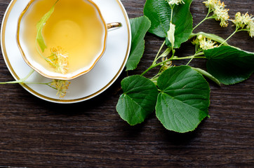 porcelain Cup of Linden tea on a background of dark wood