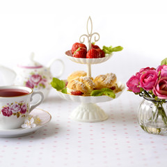 Cream puffs or profiterole filled with whipped cream served with strawberries in plateau on a breakfast table
