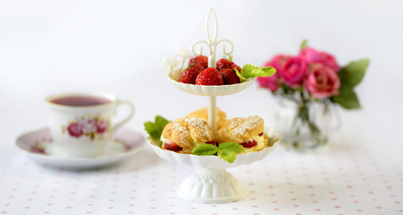 Cream puffs or profiterole filled with whipped cream served with strawberries in plateau on a breakfast table