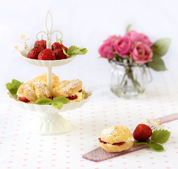 cream puffs or profiterole filled with whipped cream served with strawberries in plateau