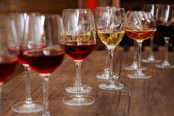 Many glasses of different wine in a row on bar counter