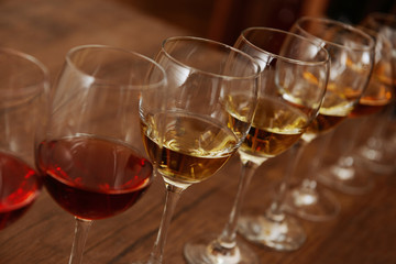 Many glasses of different wine in a row on bar counter