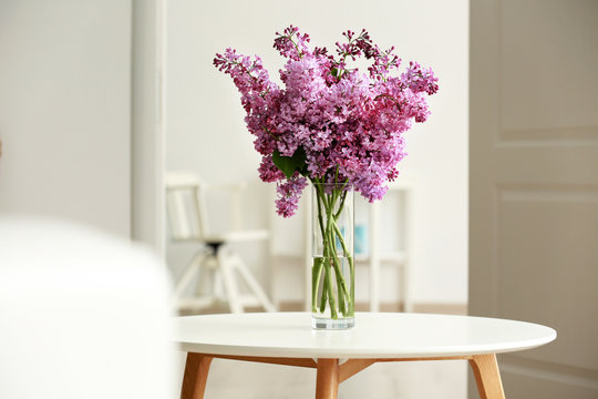 Bouquet of purple lilac flowers on white wooden table