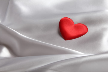 Red heart on white silk