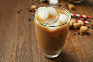 Iced coffee with milk on wooden background