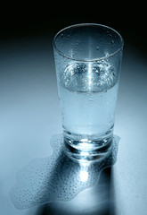 Glass and some mineral water on blue background