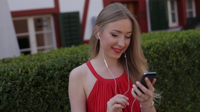 Young girl listening to music on your phone through the app