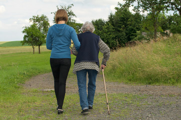 Junge Frau und Seniorin gehen spazieren