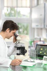 Male researcher with microscope in modern research facility