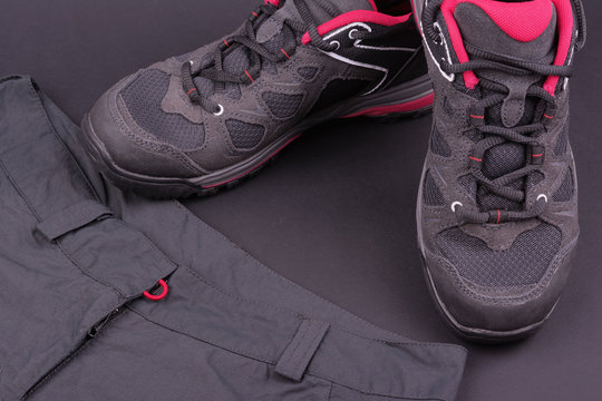 Women's hiking boots and trousers on black background
