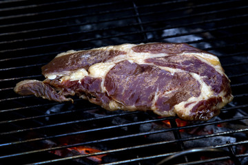beef steak cooking on an open flame grill